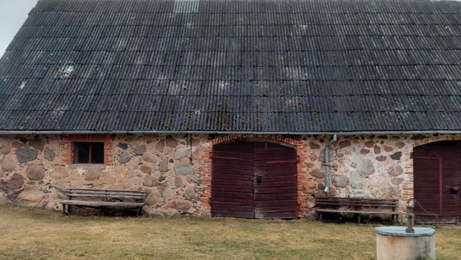 Akmens māja ar labotu jumta daļas bojājumu