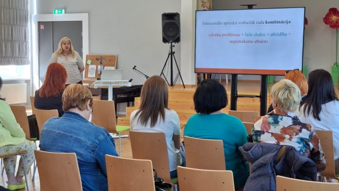 Zāles priekšā uzstājas lektore