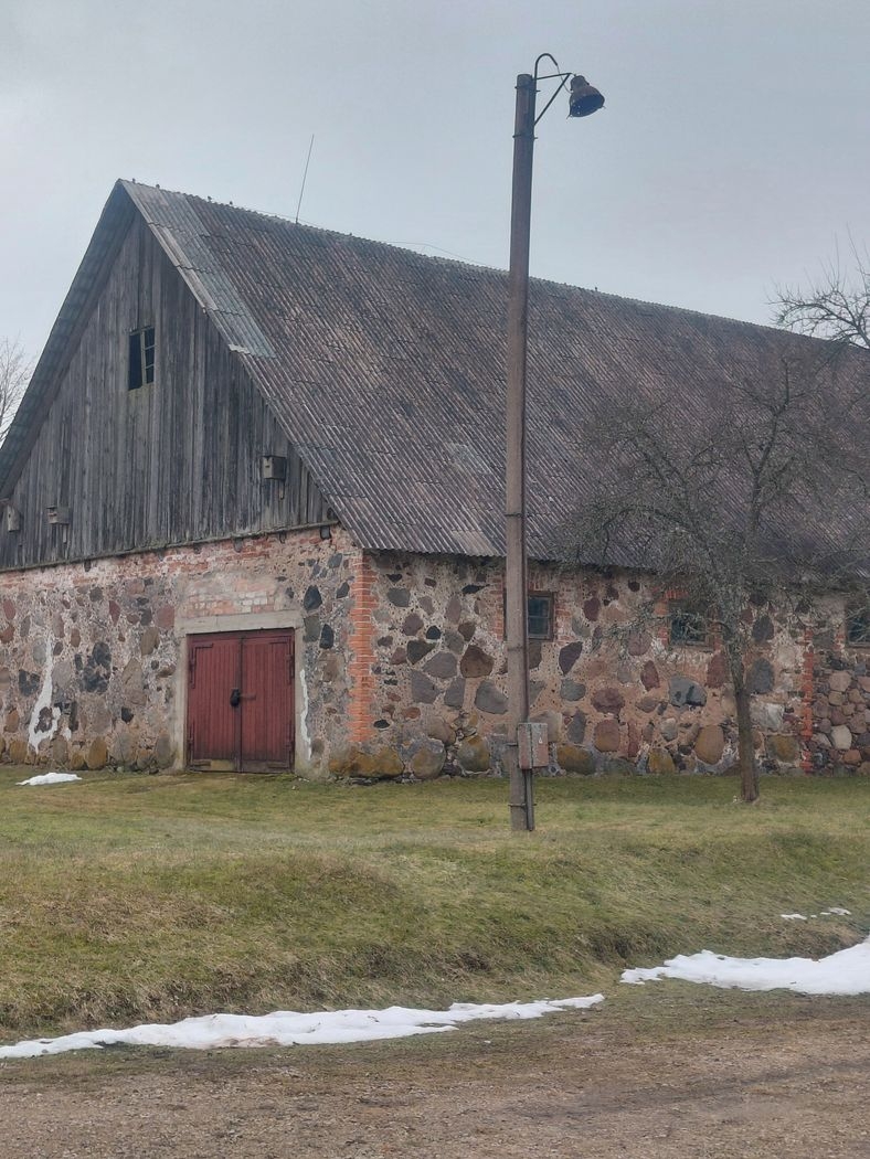 Akmens māja ar labotu jumta daļas bojājumu