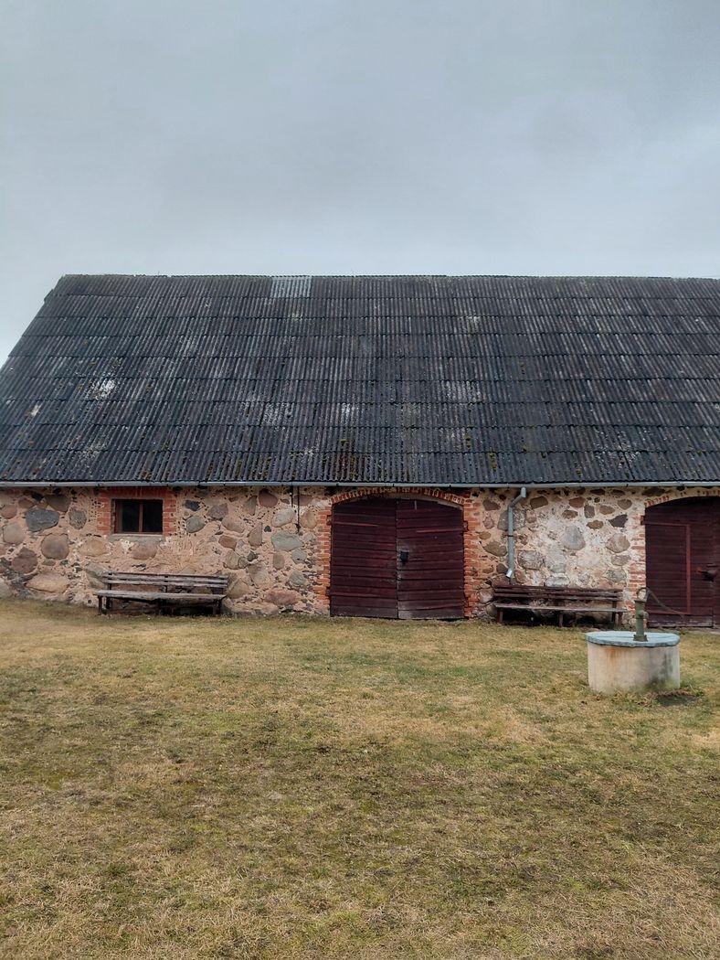 Akmens māja ar labotu jumta daļas bojājumu