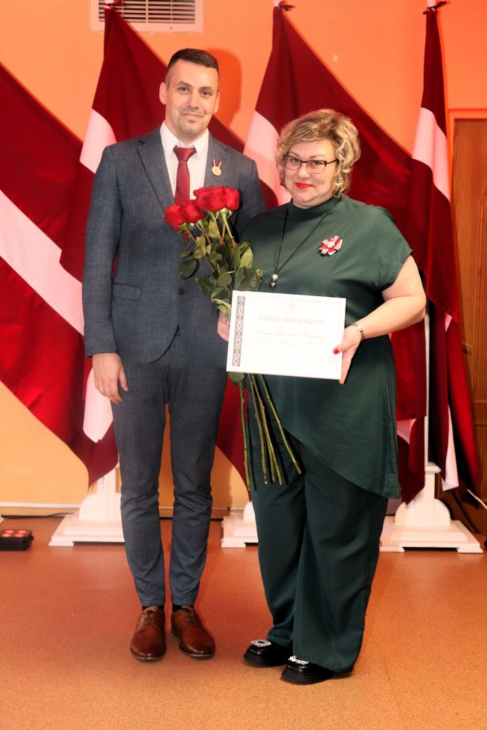 Apbalvojumu saņēmušais darbinieks bildē ar iestādes direktoru