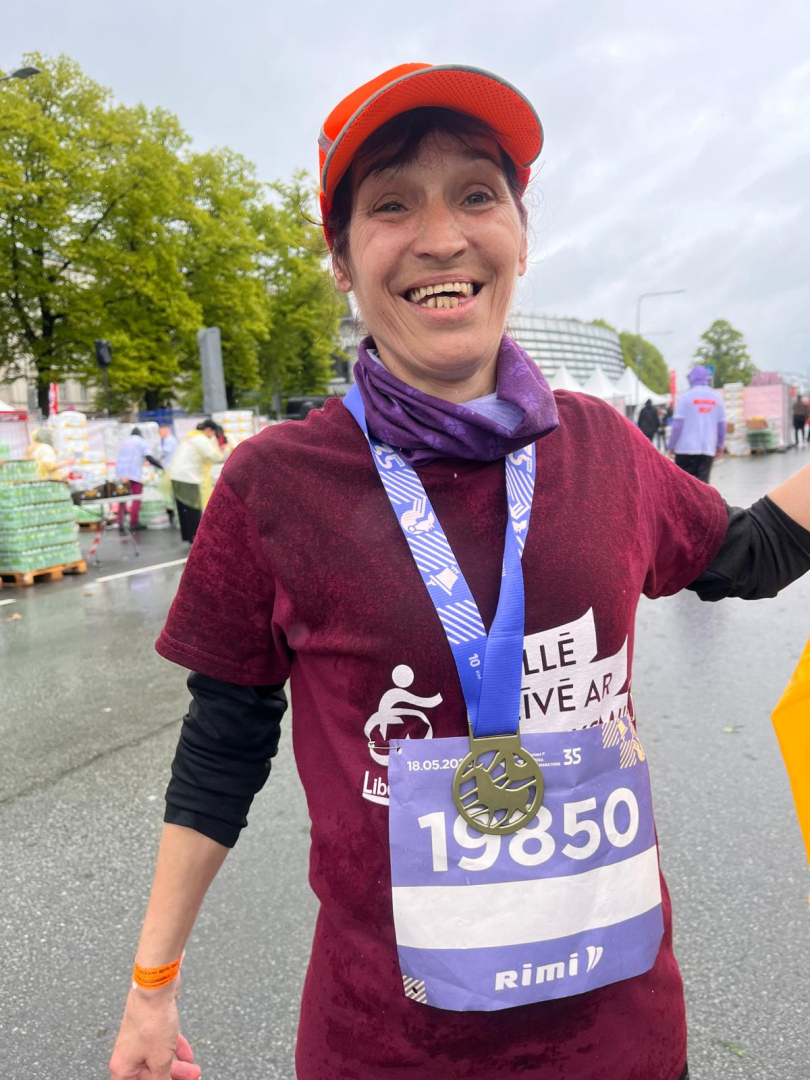 Rimi Rīgas maratona dalībniece pēc distances veikšanas. Smaidīga, ar medaļu