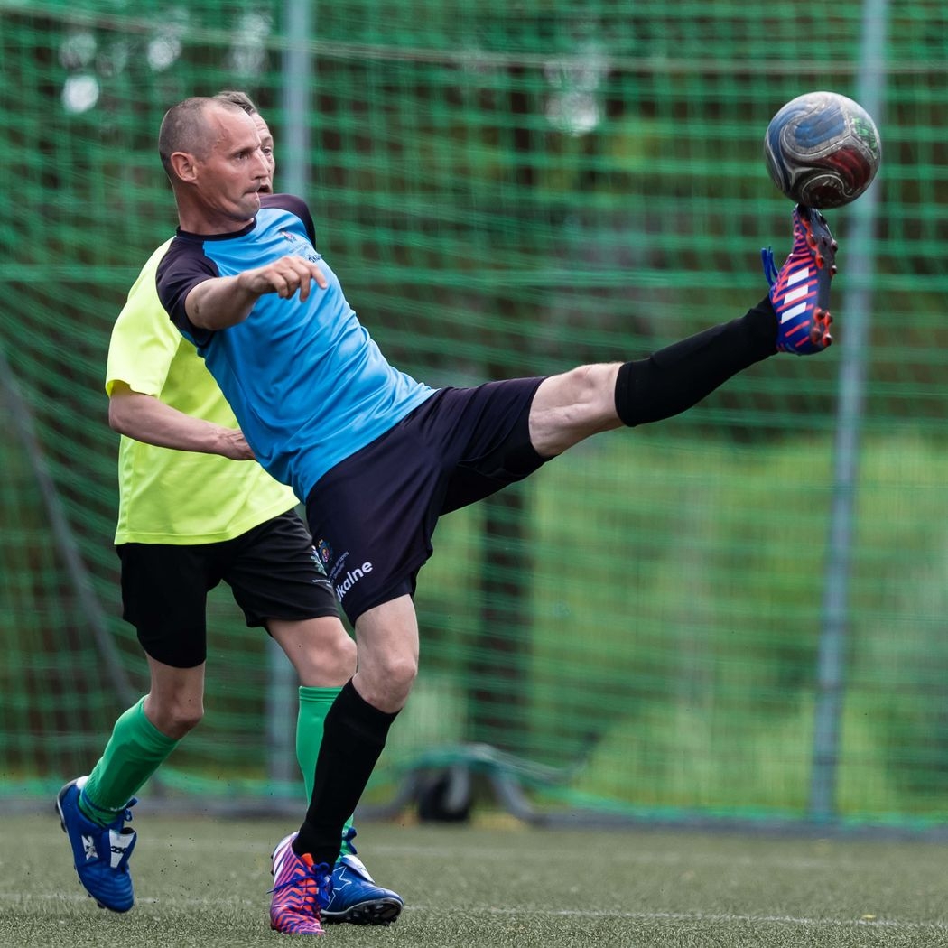 Futbolists sper bumbu ar augstu paceltu kāju