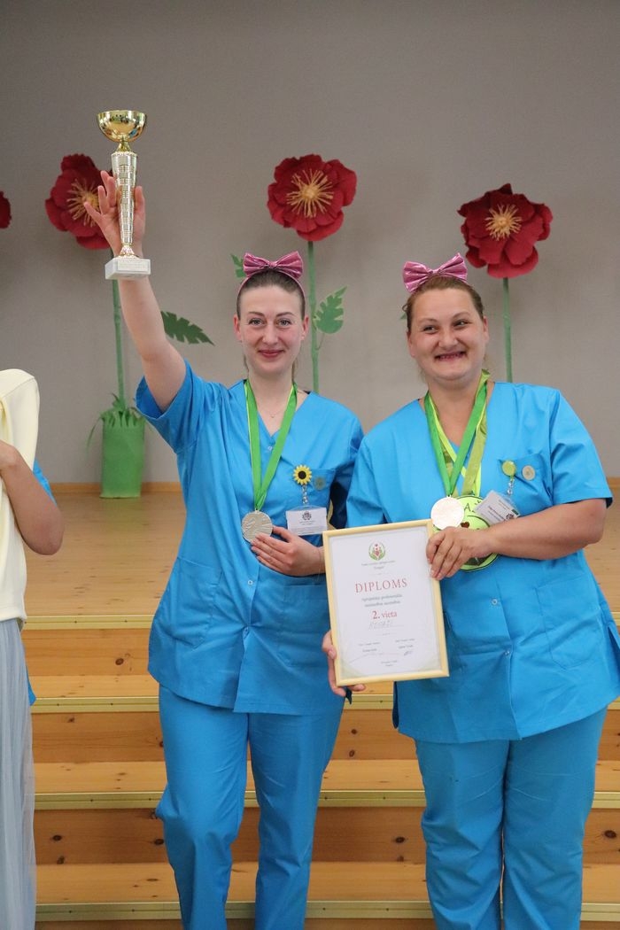 Divas dalībnieces laimīgas ar augstu paceltu iegūto kausu