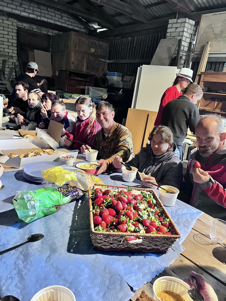 Talcinieku kompānija pie galda ēd
