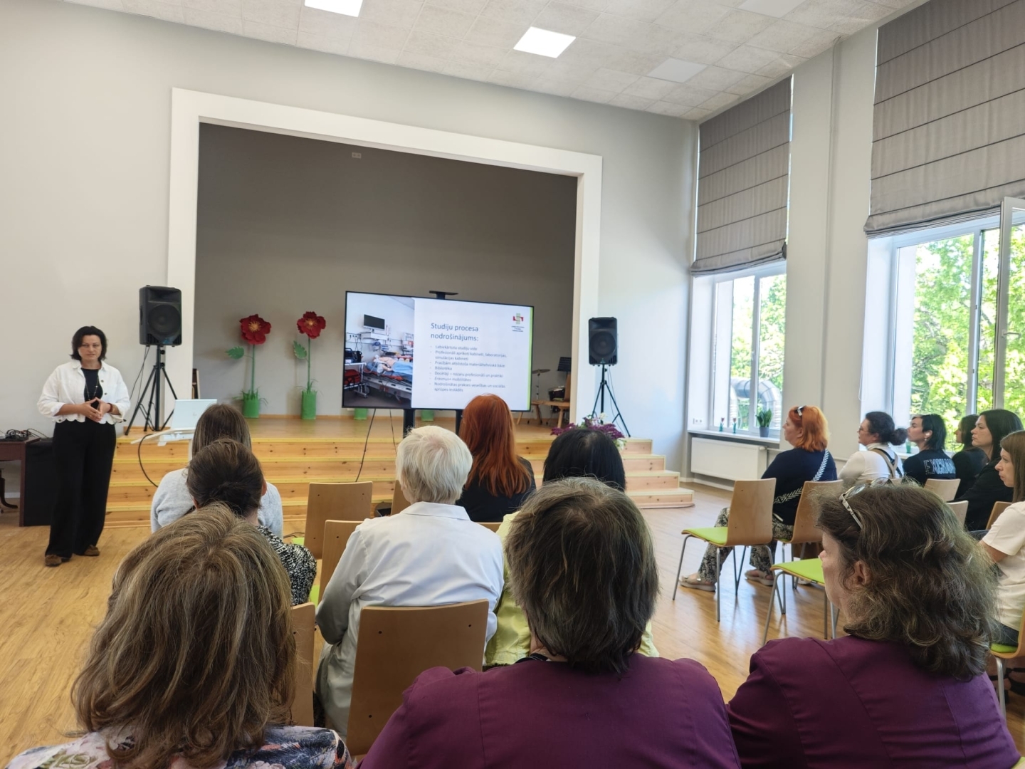 Zāles priekšā uzstājas lektore