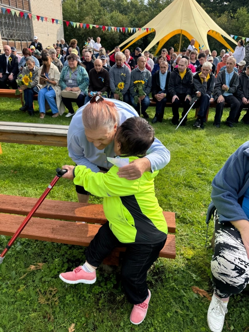 Pasākumu dalībnieki apskaujas