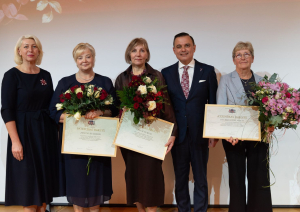 Attēlā veselības ministrs, direktora vietniece un trīs iestādes darbinieces, kuras saņēmušas ziedus un apbalvojumus