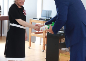 Filiāles iedzīvotāja pasniedz dāvanu labklājības ministram