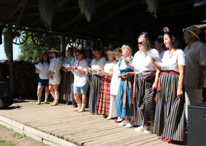 Uz skatuves filiāles Rūja darbinieku ansamblis dzied dziesmu