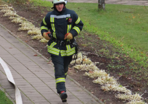 Ugunsdzēsējs steidzas dzēst ugunsgrēku