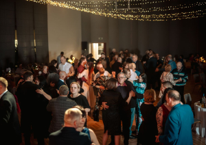 Pasākuma dalībnieki sēž pie galdiem