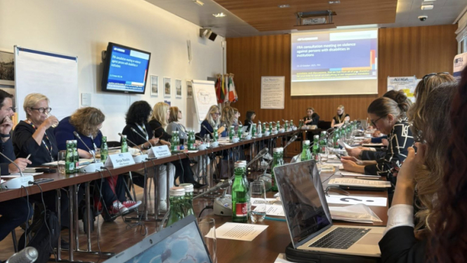 Semināra dalībnieki sēž ar datoriem pie galdiem