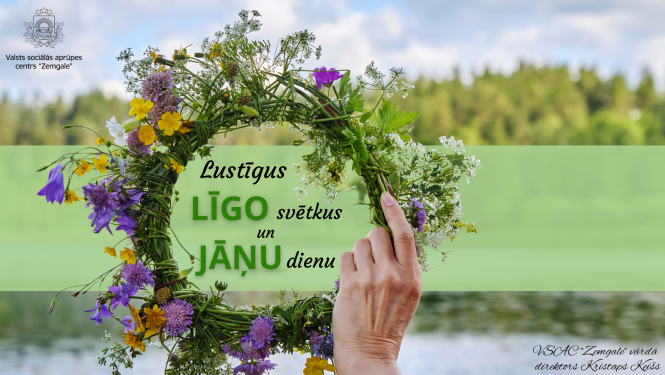 Apsveikumā dabasskats un roka, kas tur vainagu sapītu no pļavas puķēm. Uzraksts lustīgus līgo svētkus un Jāņu dienu