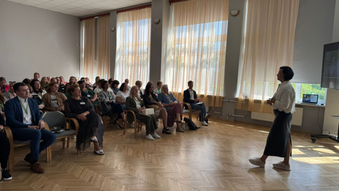 Zāle pilna ar dalībniekiem, kuri klausās runātājā