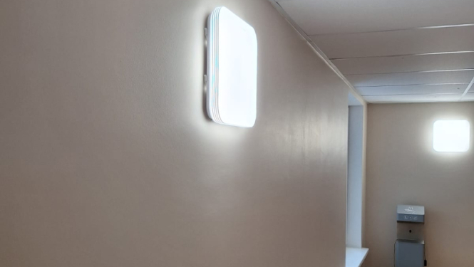 Attēlā gaitenis, kurā pie sienas pievienoti jaunie gaismekļi