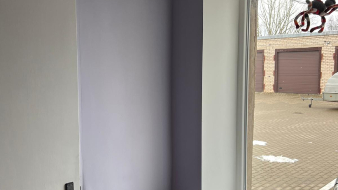 Telpa pēc remonta veikšanas. Gaišas ceriņkrāsas sienas, logs, durvis