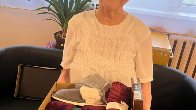 Smaidīga iedzīvotāja ar dāvanu rokās