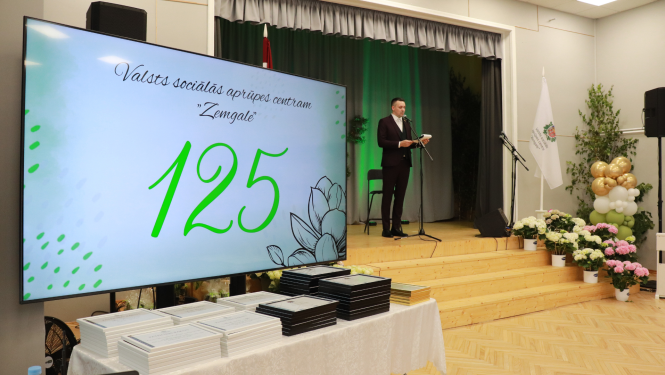 Uz skatuves iestādes direktors saka svētku uzrunu