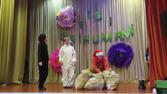 Dalībnieki uz skatuves rāda teatrālu priekšnesumu