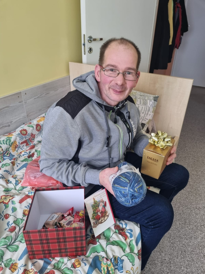 Smaidīgs iedzīvotājs ar dāvanu rokās