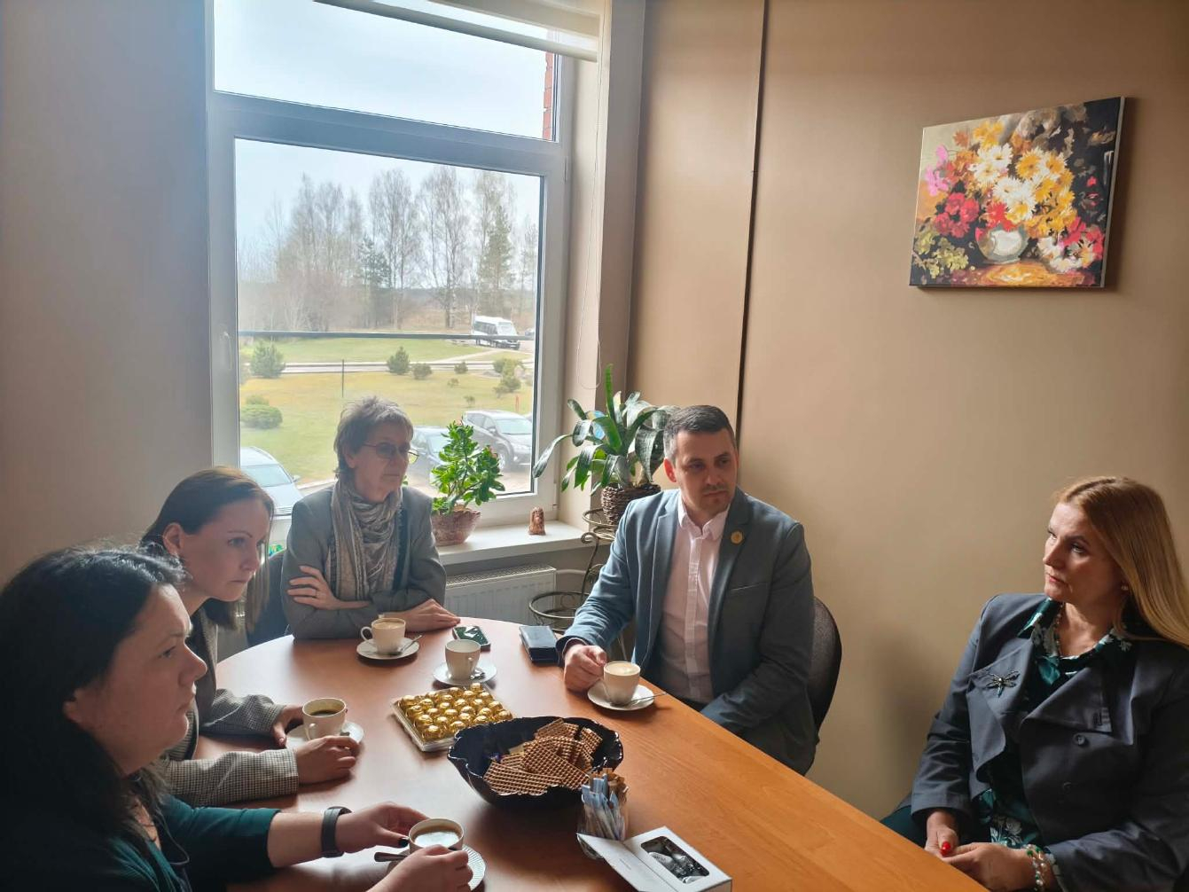 Cilvēki sarunājas pie kafijas tases