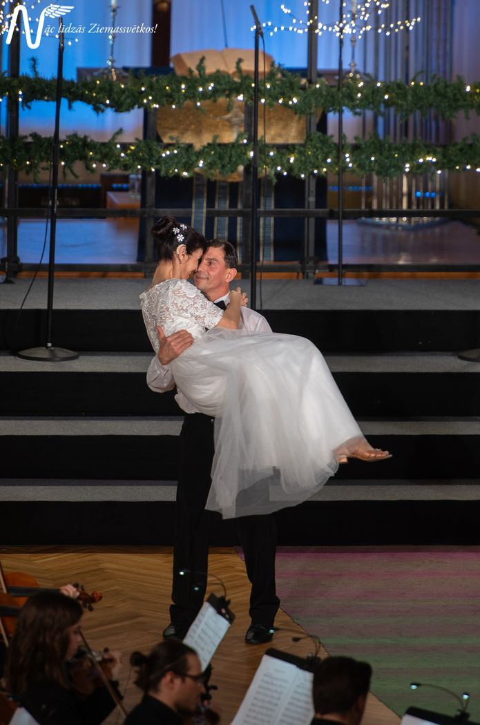 Pasākuma dalībnieki, dejotāji baltajos tērpos dejo 