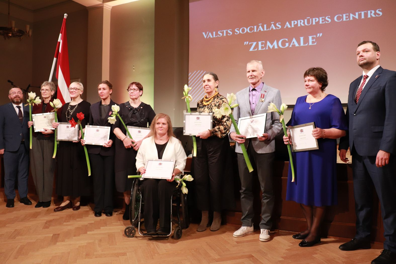 Labklājības ministrs un valsts sekretārs sveic VSAC Zemgale darbiniekus. Kopbilde