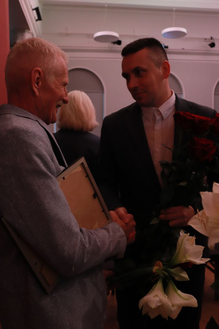 Iestādes direktors Kristaps Keišs sveic apbalvojumu saņēmušo darbinieku