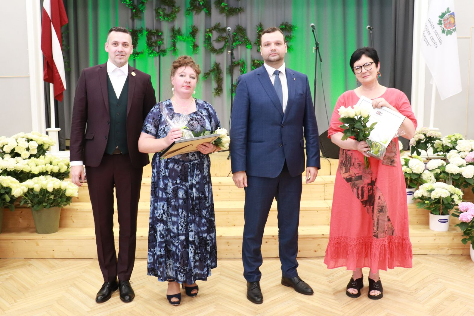 Labklājības ministrs un direktors ar pateicības rakstu saņēmējiem