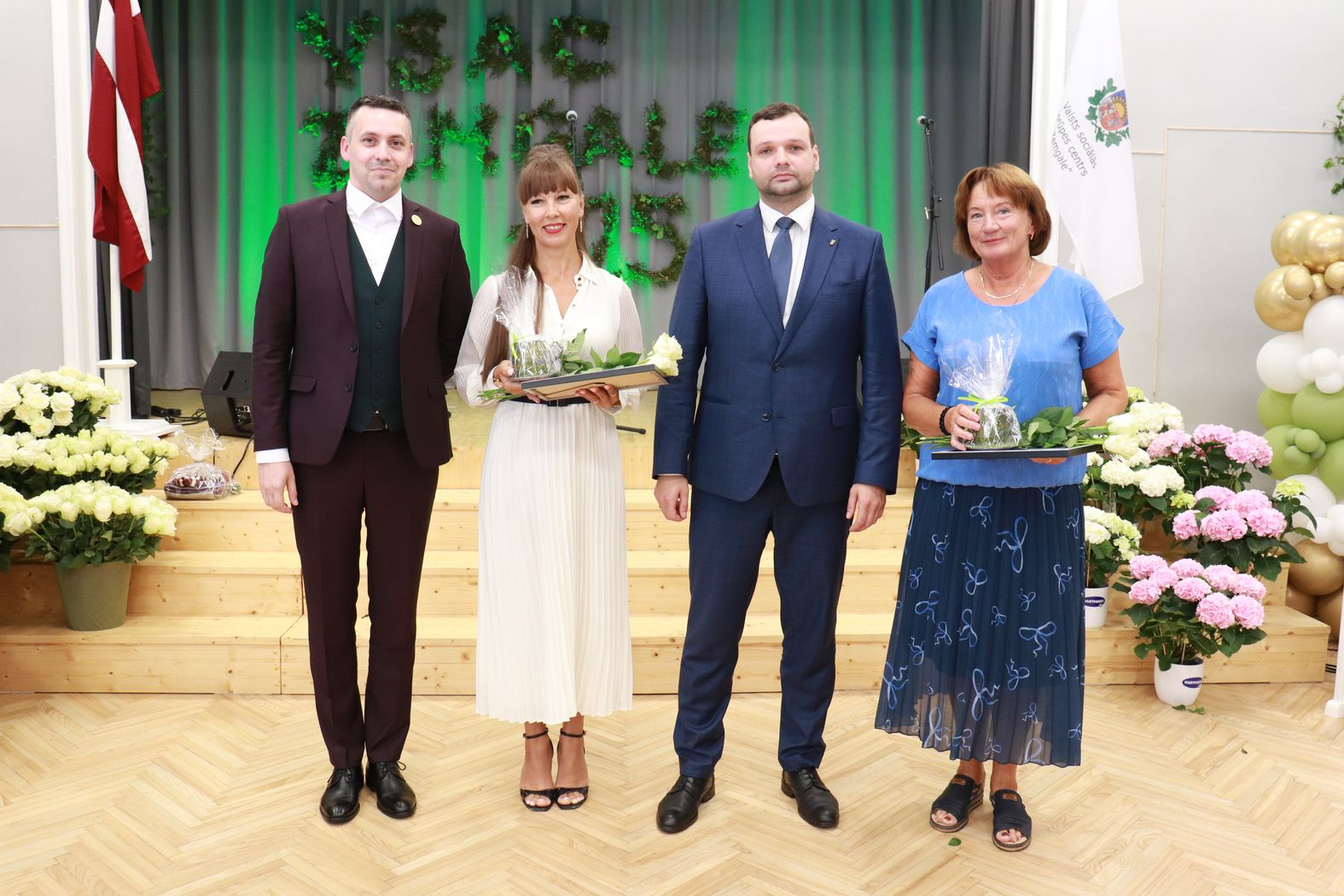 Labklājības ministrs un direktors ar pateicības rakstu saņēmējiem