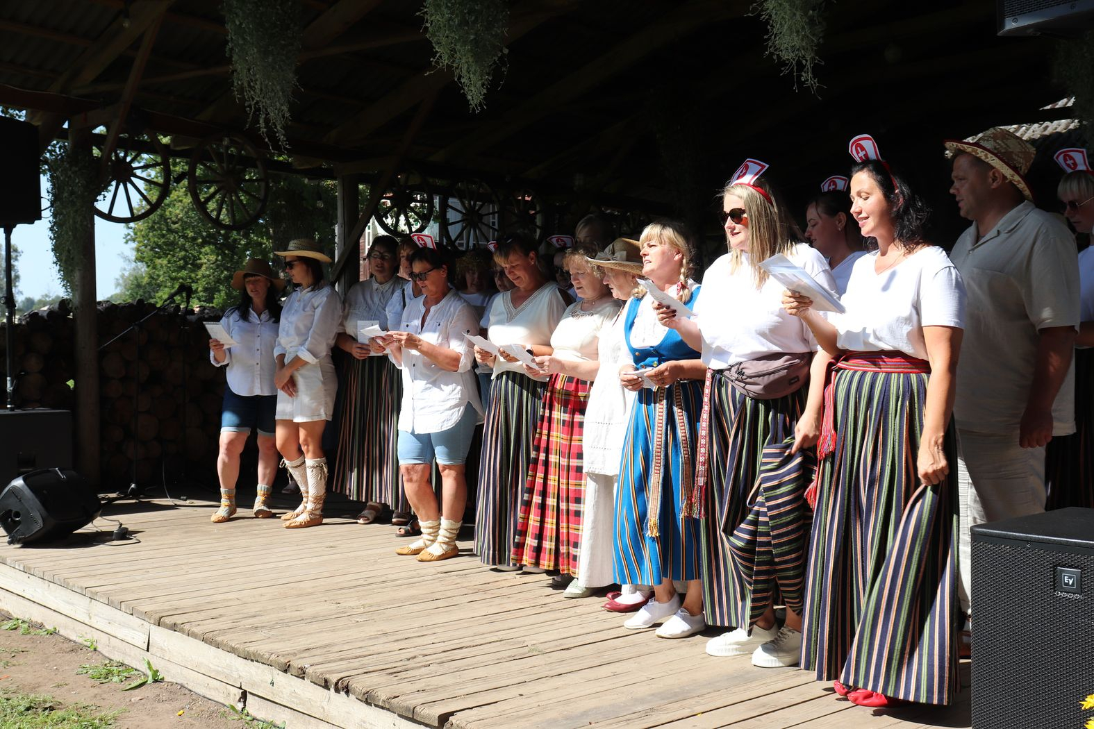 Uz skatuves filiāles Rūja darbinieku ansamblis dzied dziesmu