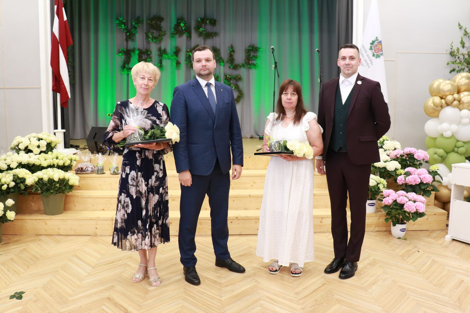Labklājības ministrs un direktors ar pateicības rakstu saņēmējiem