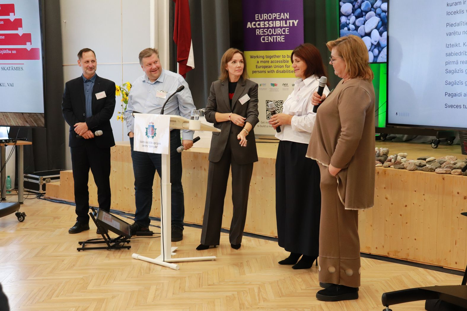 Uz skatuves lektore un pieaicinātie dalībnieki no zāles, kuri atbild uz jautājumiem