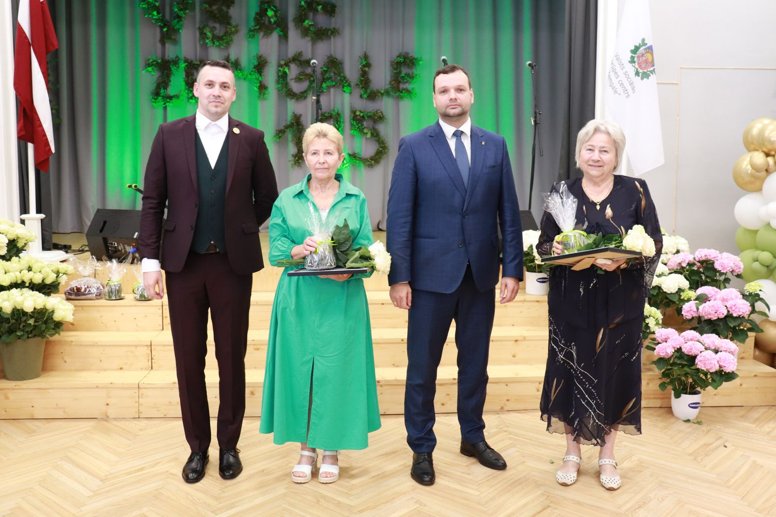 Labklājības ministrs un direktors ar pateicības rakstu saņēmējiem