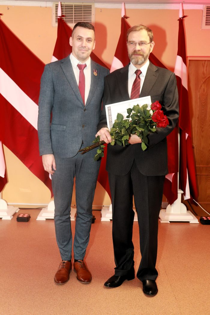 Apbalvojumu saņēmušais darbinieks bildē ar iestādes direktoru