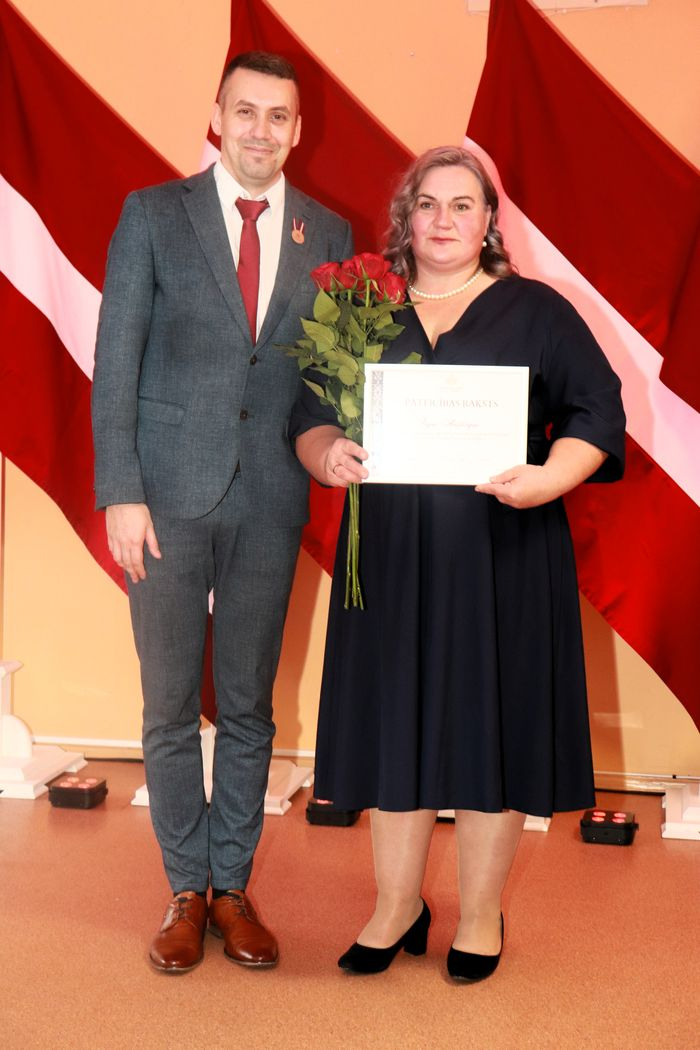 Apbalvojumu saņēmušais darbinieks bildē ar iestādes direktoru