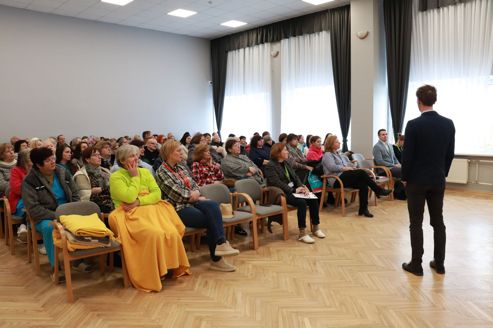 Zālē sēž darbinieki, priekšā struktūrvienības vadītājs vada kopsapulci