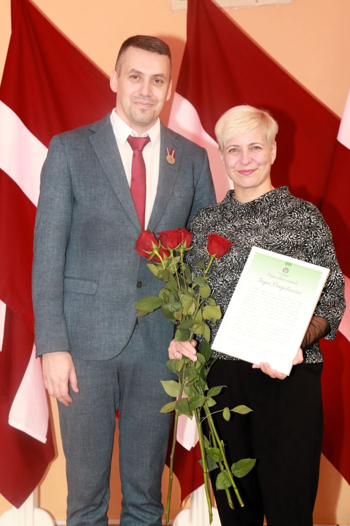 Apbalvojumu saņēmušais darbinieks bildē ar iestādes direktoru