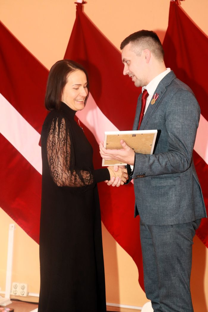 Apbalvojumu saņēmušais darbinieks bildē ar iestādes direktoru