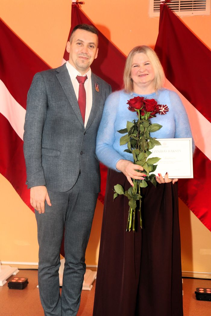 Apbalvojumu saņēmušais darbinieks bildē ar iestādes direktoru