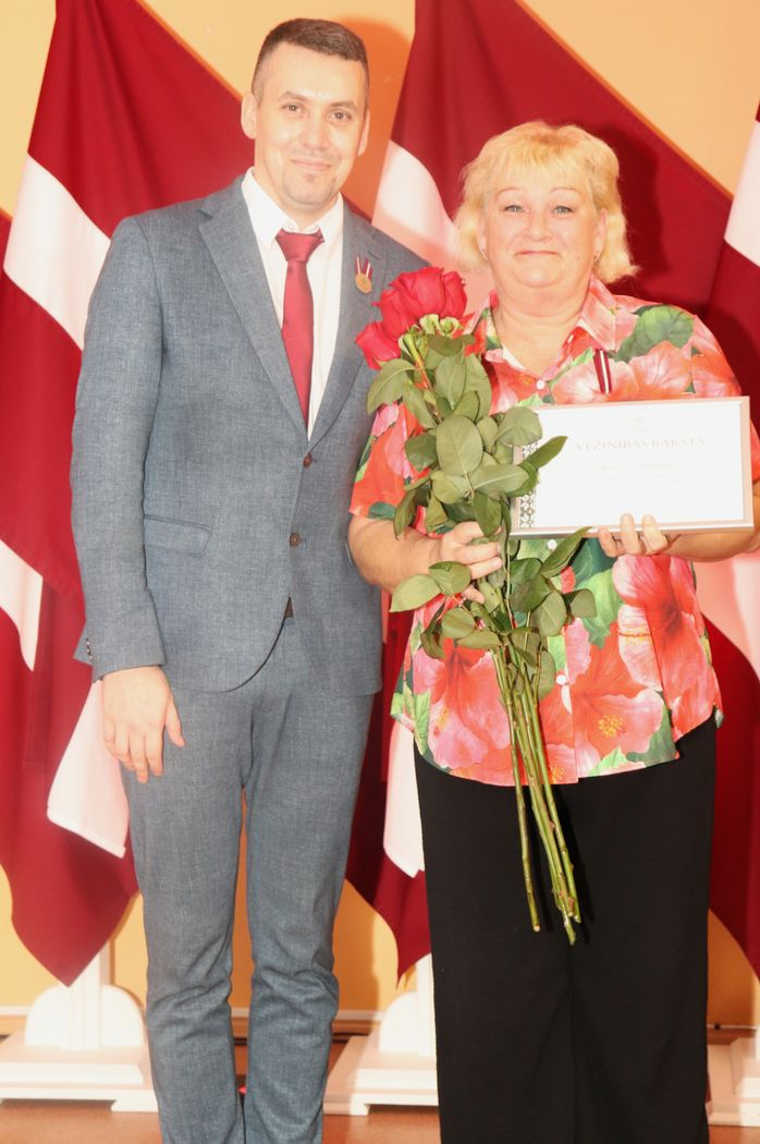 Apbalvojumu saņēmušais darbinieks bildē ar iestādes direktoru