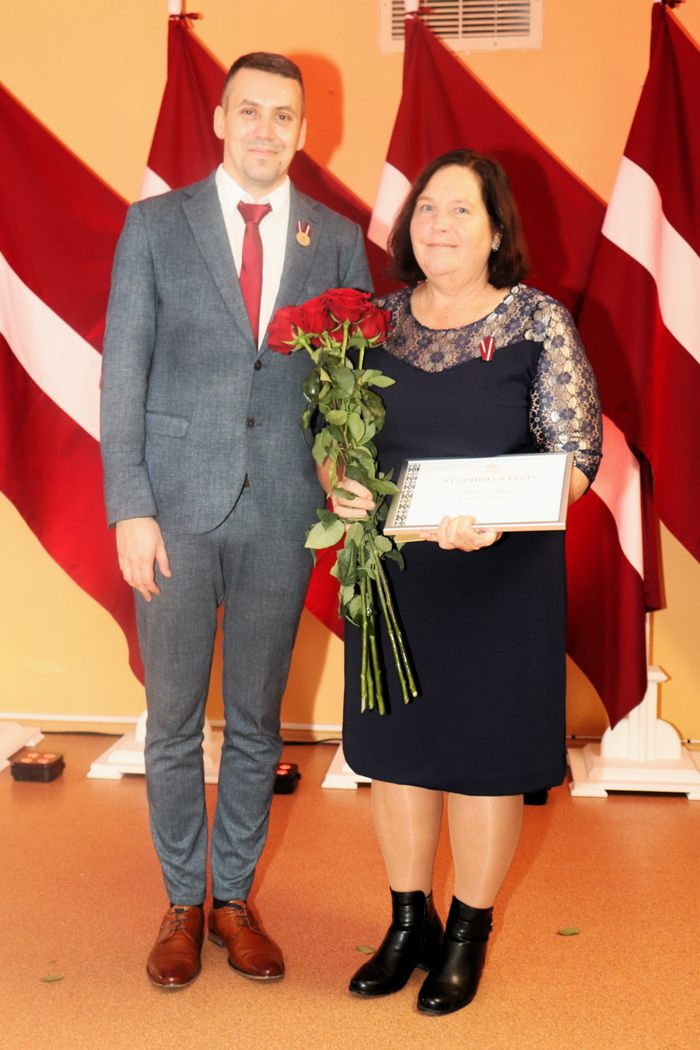 Apbalvojumu saņēmušais darbinieks bildē ar iestādes direktoru