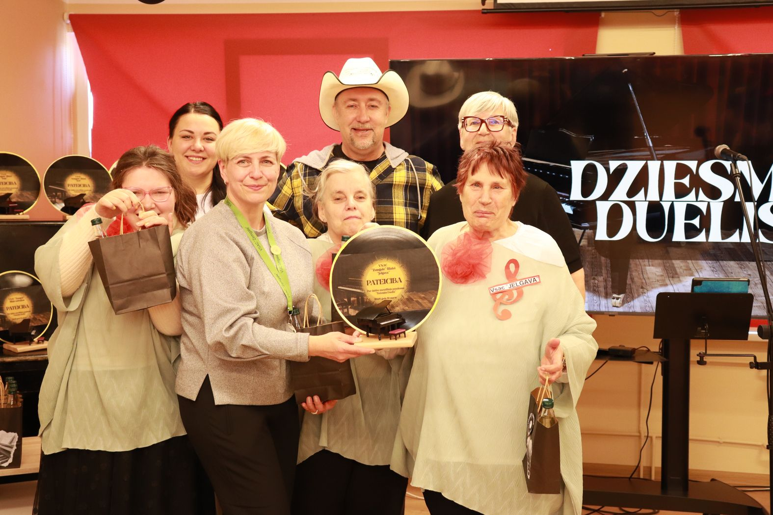 Dalībnieku komandas kopbilde ar balvām un pateicību par dalību