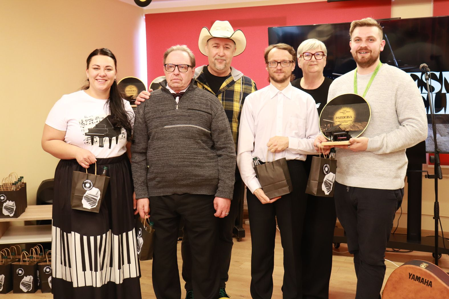 Dalībnieku komandas kopbilde ar balvām un pateicību par dalību