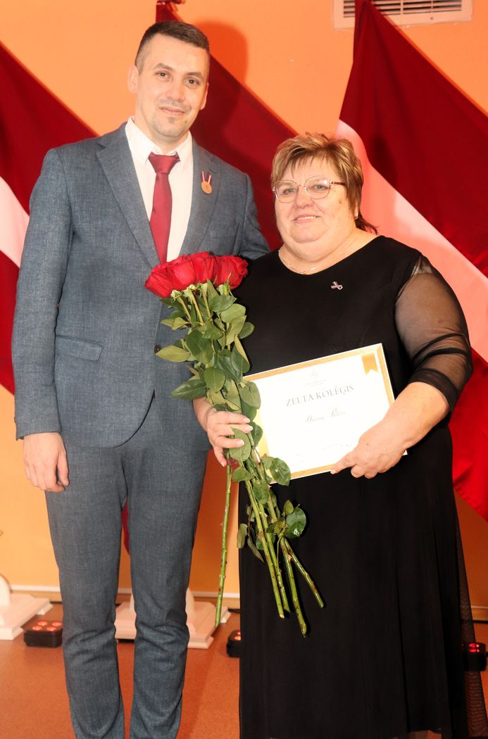 Apbalvojumu saņēmušais darbinieks bildē ar iestādes direktoru