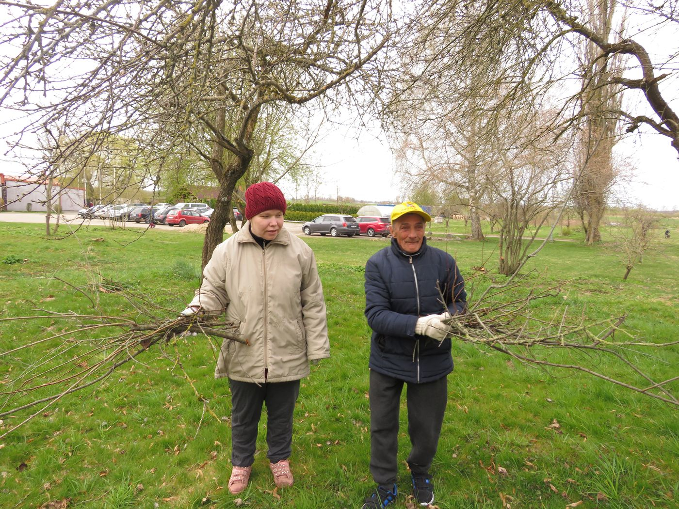 Cilvēki veic teritorijas uzkopšanas darbus