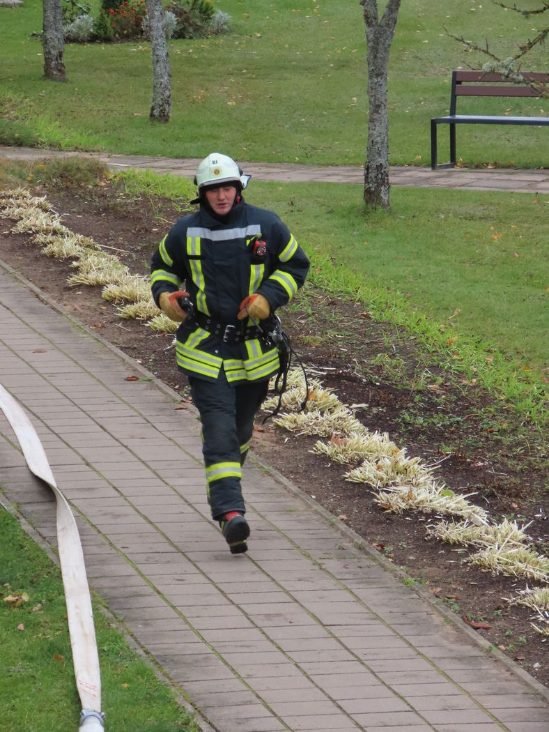 Ugunsdzēsējs steidzas dzēst ugunsgrēku