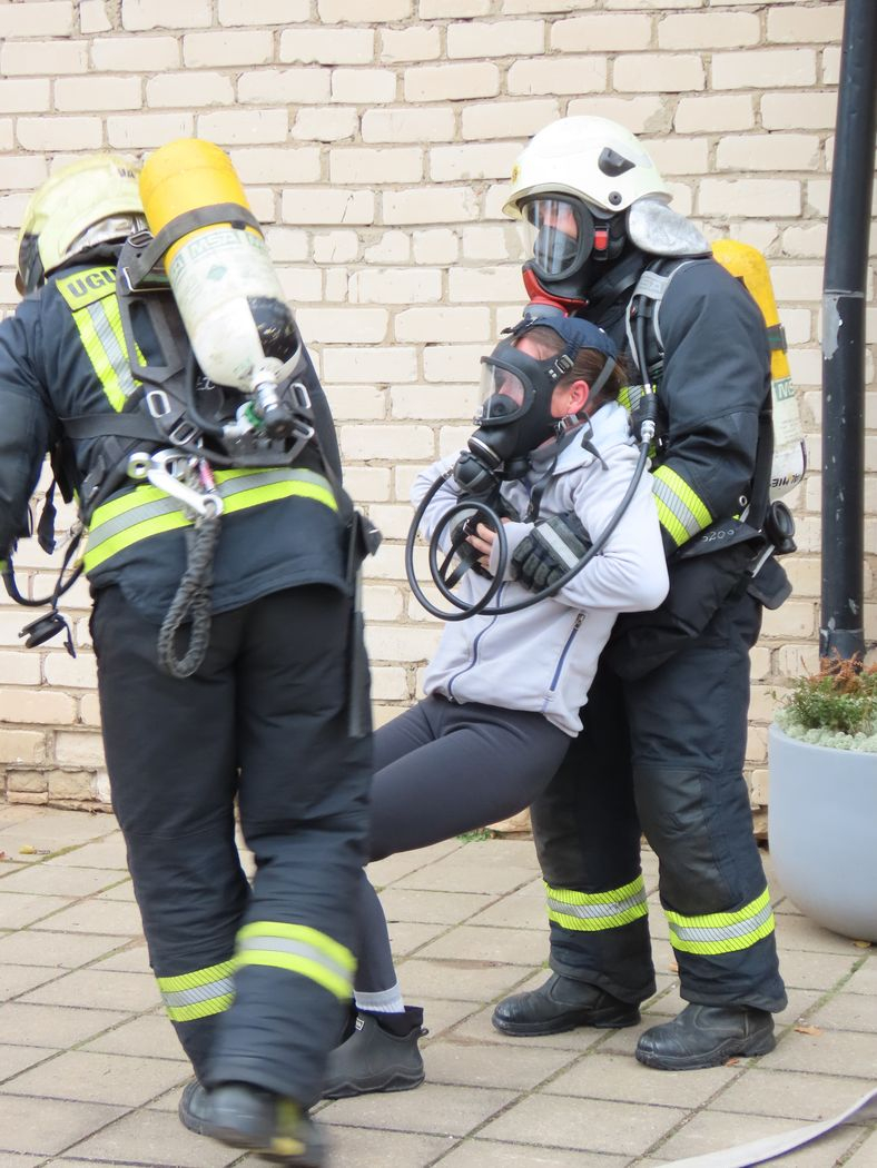 Divi ugunsdzēsēji no ēkas iznes cilvēku maskā