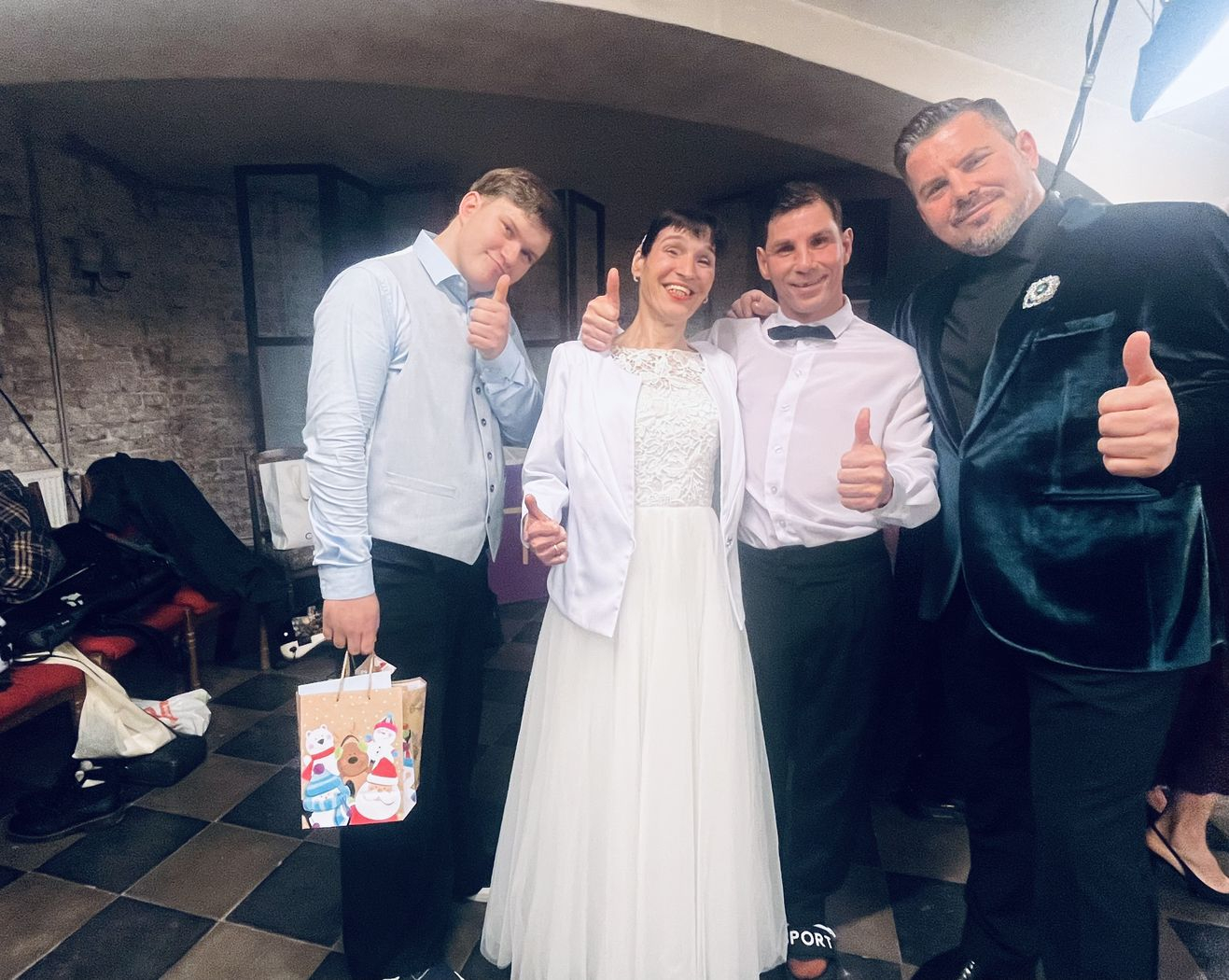 Pasākuma dalībnieki, dejotāji baltajos tērpos kopā ar dziedātāju Intaru Busuli